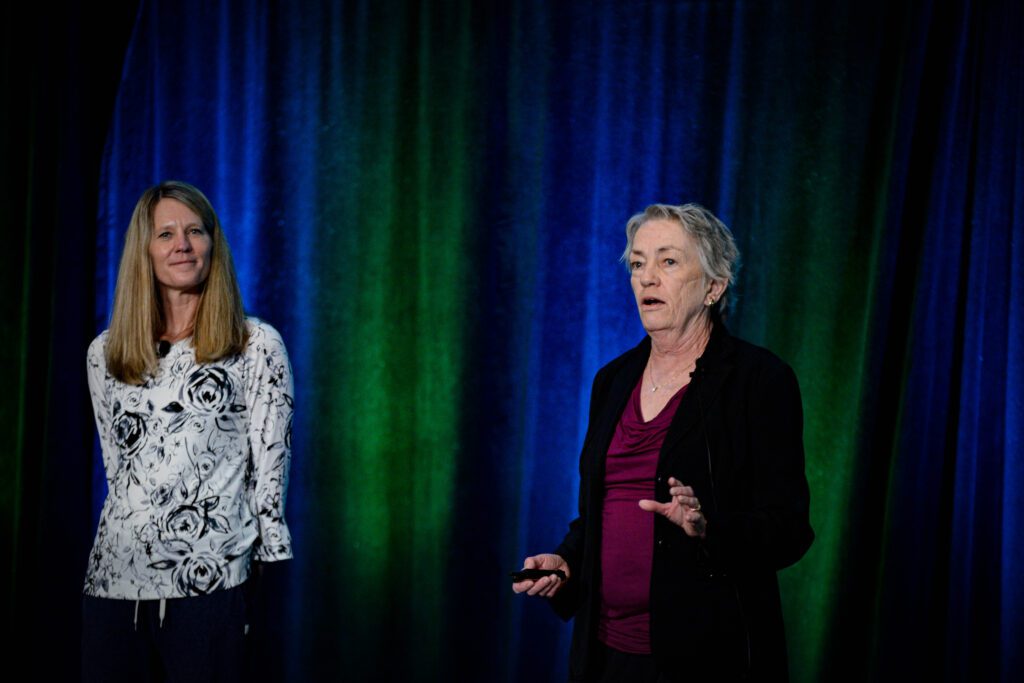 Color photo from the 2023 NCWIT Summit of Executive Director Terry Hogan and Founder Lucy Sanders on the plenary stage.